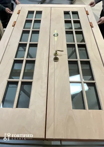 View from above of bullet resistant double french door with wood finish on factory table.