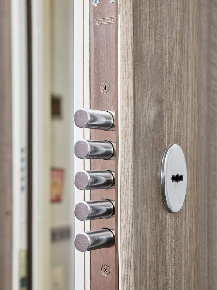 Edge of a wood-clad safe room door with its steel bolts thrown.