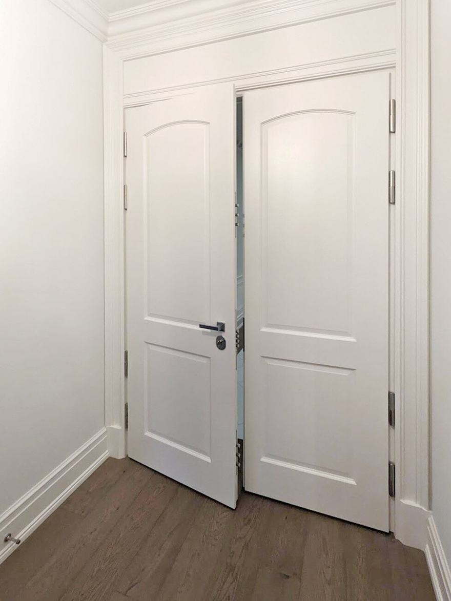 Pair of white milled double doors in a hallway.