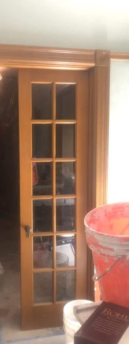 Glazed French doors in the same opening during the renovation, building materials in front.